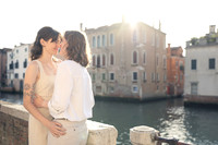 Couple standing at Venice waterfront during sunset