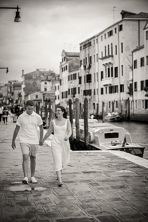 Engaged couple walking by the Venetian canal