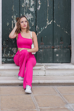 Model walking past a historic building in Venice.