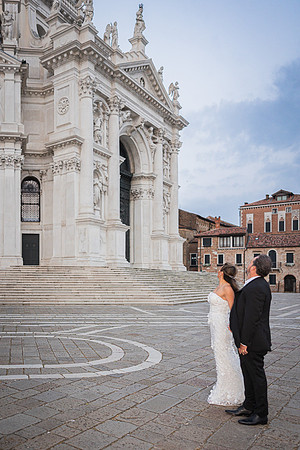 Bride standing alone at Punta della Dogana before sunrise - Anniversary sunrise photoshoot in Venice.