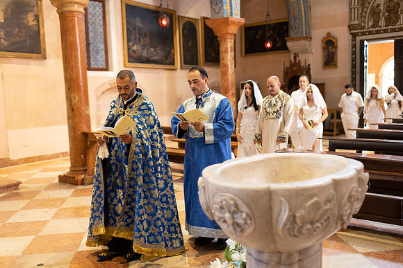 Priest reading blessing baptismal font