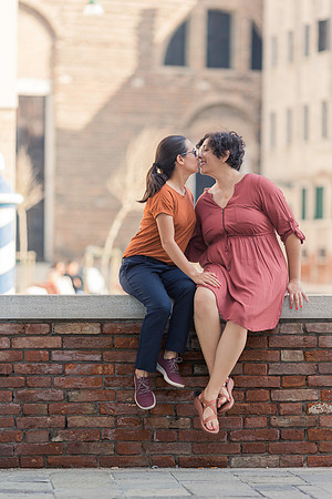 Couple embracing by the water in Venice during autumn engagement.