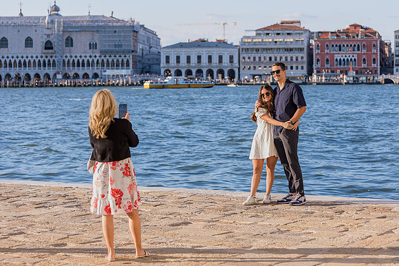 A couple shares a heartfelt embrace after a romantic proposal in Venice.