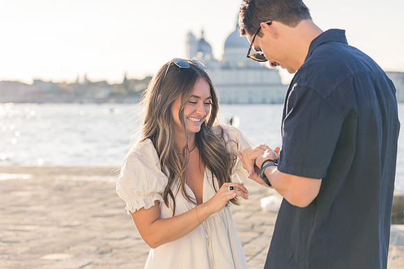 A surprise engagement moment with the iconic skyline of Venice in the background.