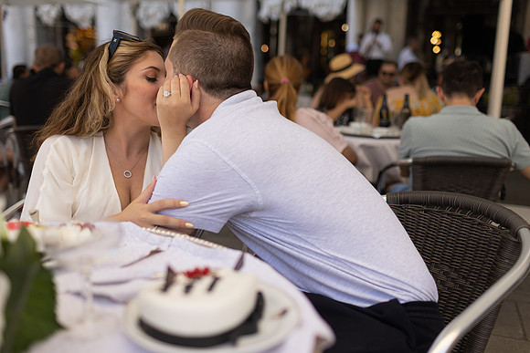 Engaged couple laughing at Café Florian