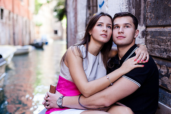 Couple embracing near a historic Venetian wall