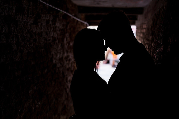 Silhouette of a couple embracing in a dark Venetian alley