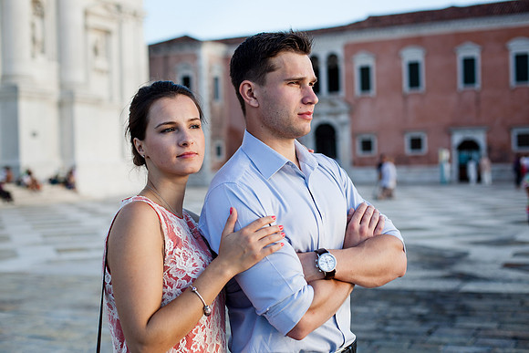 Engaged couple standing near the Venetian waterfront after their proposal