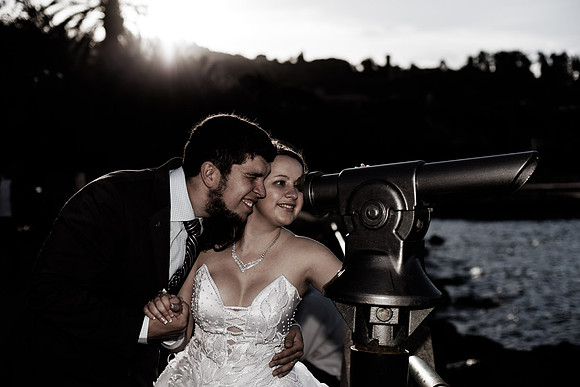 Bride and groom posing by the lake during sunset.