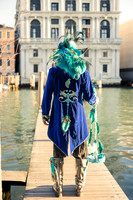 Couple in ornate handmade costumes posing on a pier in Venice