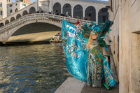 Couple in spectacular handmade costumes with the Rialto Bridge in the background