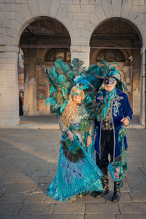 Couple in carnival attire standing between classical columns in the Riallo fish market
