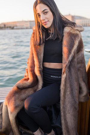 Reflective moment in fur coat on a water taxi in Venice
