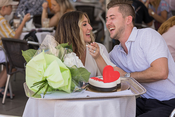 Engaged couple laughing at Café Florian
