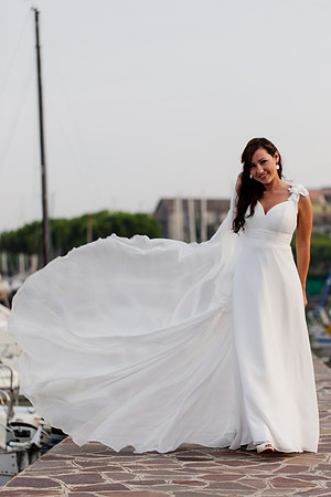 Bride holding her dress as the wind blows through it in Desenzano.