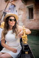Family relaxing on a gondola ride through Venice with Venetian architecture in the background