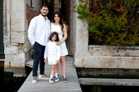 Family posing near a Venetian canal for a casual photo session
