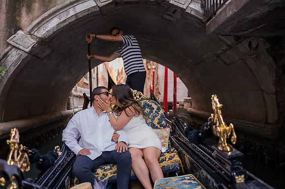 Couple sharing a romantic moment on a gondola ride in Venice