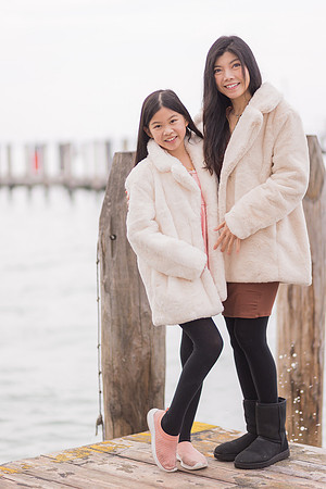 Sisters standing by the waterfront in Venice during the winter.
