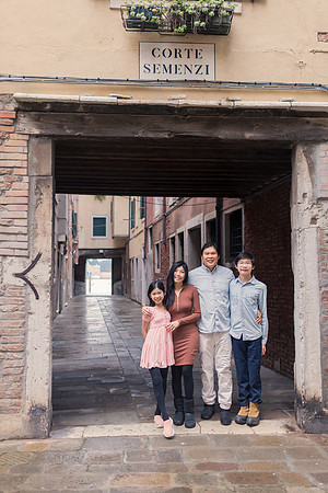 Family standing under a Venetian archway during their winter vacation.