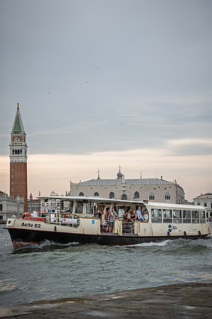 Boat sailing in front of Piazza San Marco in Venice at dusk.