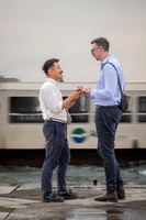 Engaged gay couple standing and holding hands after the proposal.