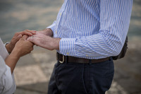 Close up of hands putting an engagement ring on a finger.