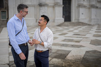 Engaged couple walking and smiling in a Venetian courtyard.
