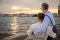 Back view of couple looking out at the Venice lagoon sunset.