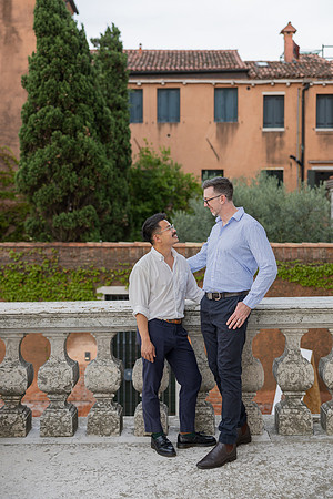 Couple walking together in a green garden setting in Venice.