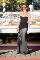 Full length photo of Sunny Mittmann in a long black dress standing on a dock.