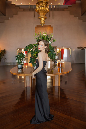 Full body portrait of Sunny Mittmann standing in a grand hall at the Hotel Excelsior.