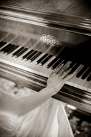Close up of hands playing a piano in black and white tones.