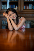 Close up of a woman leaning on a table in a library setting.