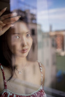 Reflection of a woman in a glass window overlooking the Venice canal.
