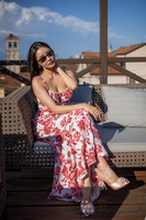 Woman sitting on a rooftop chair with Venice terracotta roofs in background.