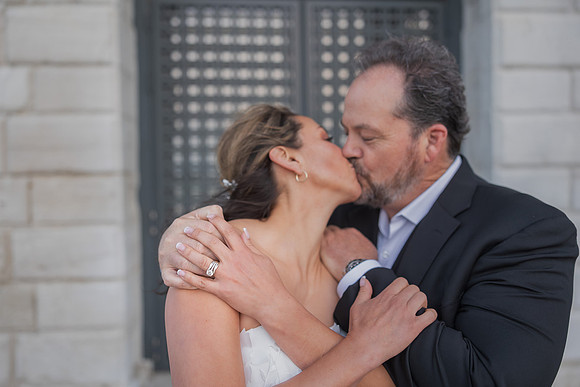 Joyful kiss beside Venetian column - Anniversary sunrise photoshoot in Venice.