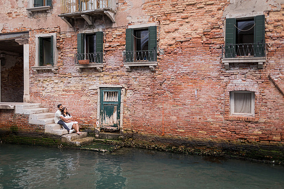 A newly engaged couple strolls through the charming streets of Venice.