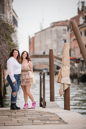Mother and daughter smiling by a Venetian canal, enjoying their photo session.