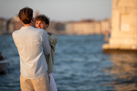 A couple by the canal during a sunset proposal