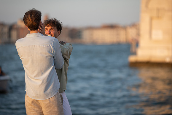 A couple by the canal during a sunset proposal