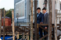 Engaged couple sharing a joyful moment near the gondolas in Venice.