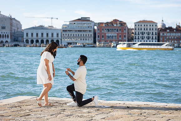 A couple celebrating their engagement at golden hour by the Grand Canal.