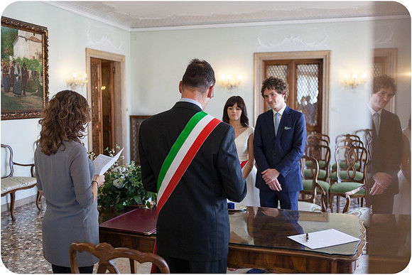 Bride and groom standing before the officiant at their wedding ceremony.