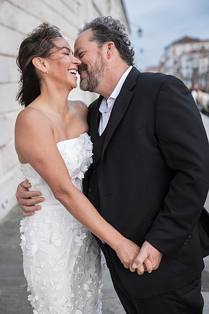 Laughing couple in wedding attire at Punta della Dogana - Anniversary sunrise photoshoot in Venice.