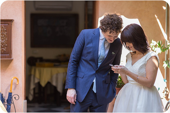 Bride and groom reading love letters together in a Venice garden.