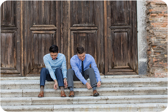 Couple sitting on historic stone steps in Venice.