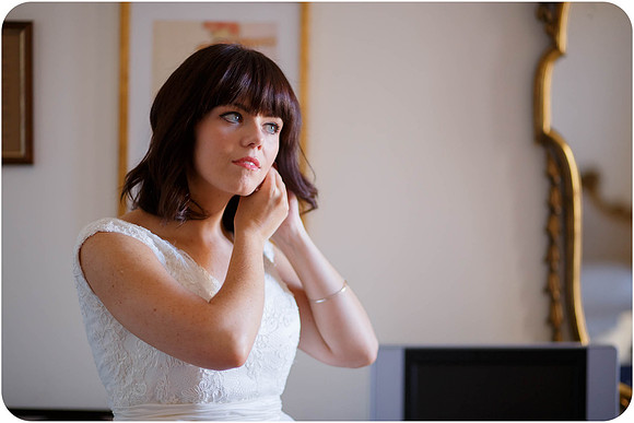 Bride fixing her earring in preparation for the civil wedding.