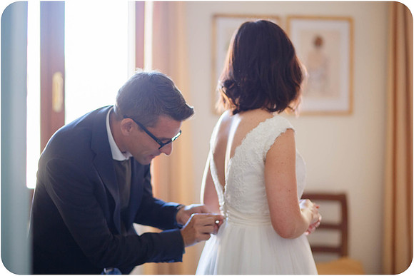 Bride standing by a window, reflecting before the ceremony.