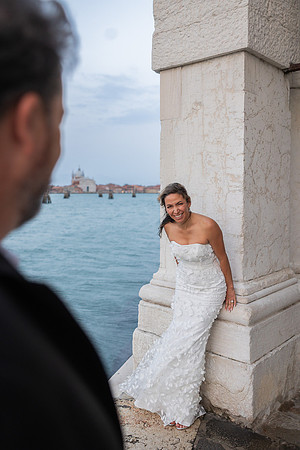 Bride leaning on a column with the Grand Canal behind - Anniversary sunrise photoshoot in Venice.